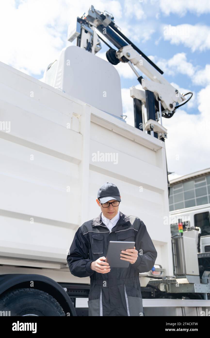 Manager with a digital tablet next to garbage truck.. Stock Photo