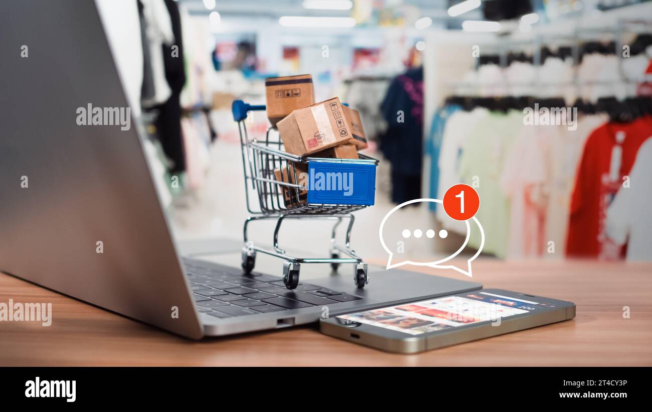 Shopping carts and product boxes Place on laptop computer showing online shopping concept, website, e-commerce, market platform, technology and online Stock Photo