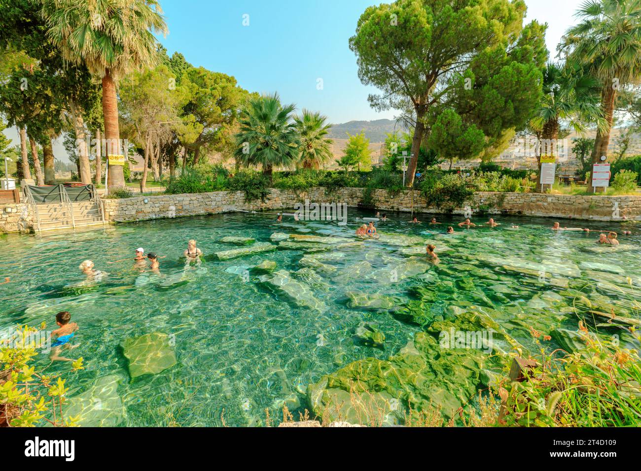 Pamukkale, Turkey - Aug 7,2023: Tourists happily immerse themselves in revitalizing thermal waters of Cleopatra Pools in Hierapolis, embracing Stock Photo