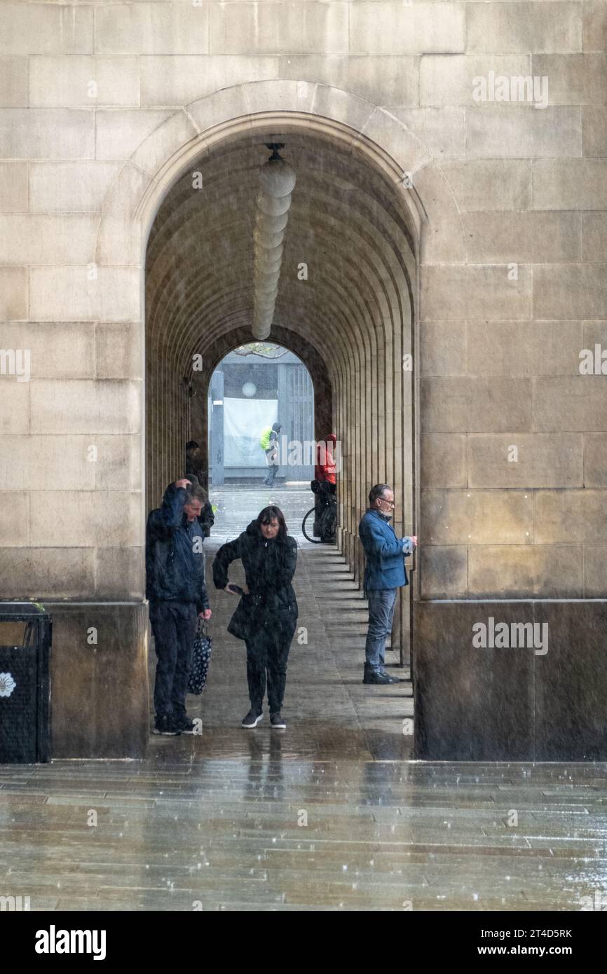 People taking shelter from the rain under the arches of Manchester Town Hall Stock Photo Alamy