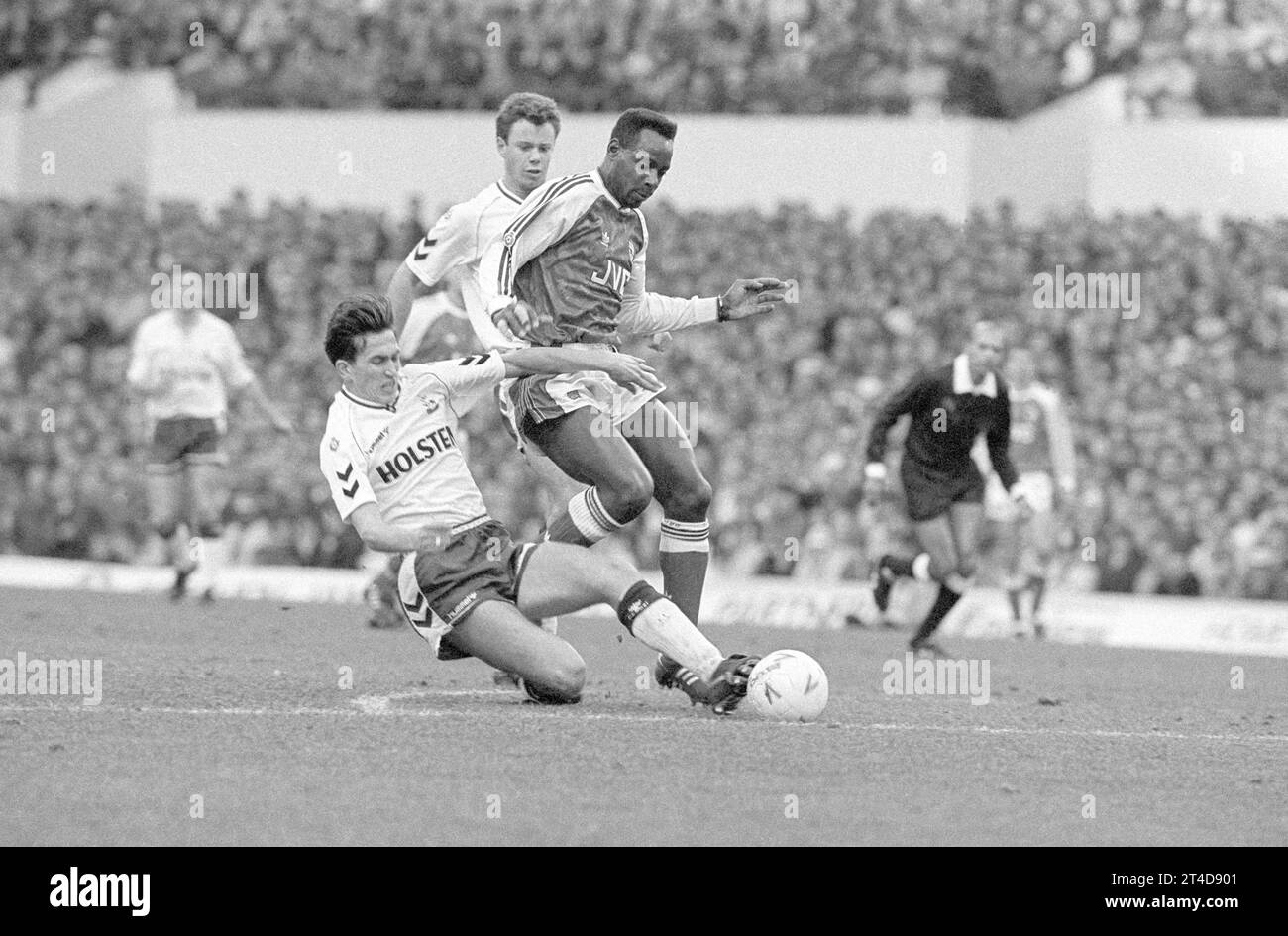 Michael Thomas (Arsenal) steps over the sliding tackle of Gary Lineker (Spurs) Stock Photo