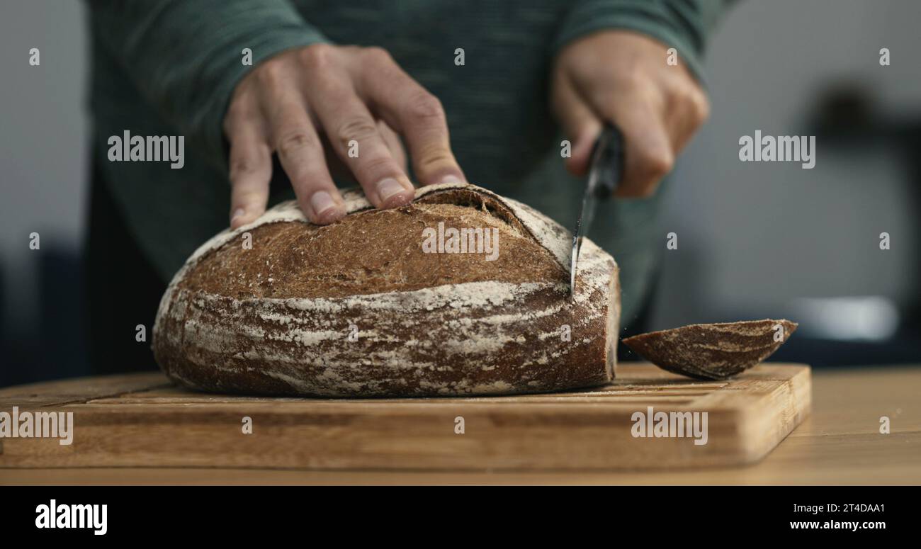 Close-up hand cutting slice of bread with knife in speed ramp Stock ...