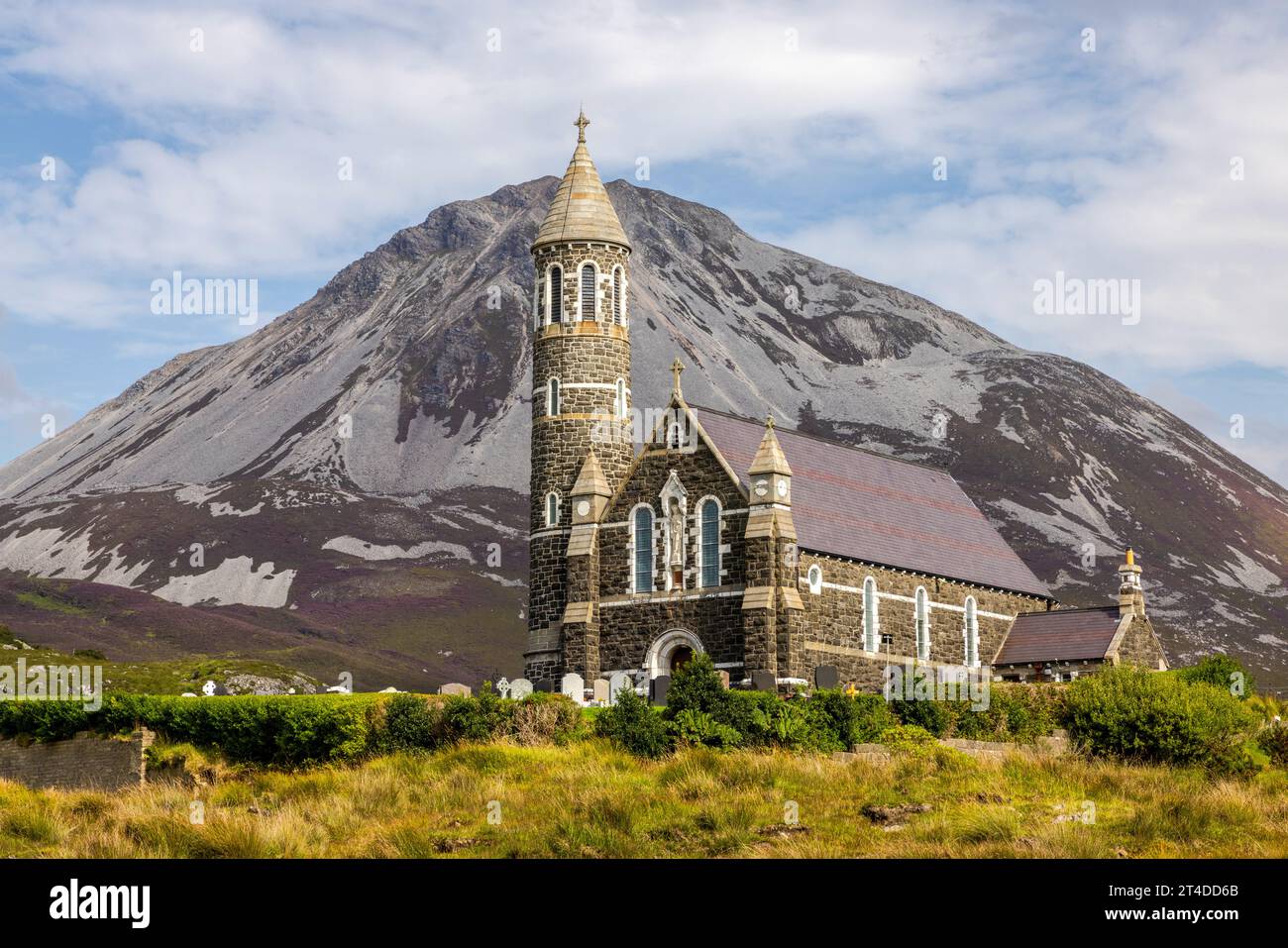 The Sacred Heart Catholic Church in Dunlewey, Ireland, is a landmark with its Hiberno-Romanesque style and round tower, nestled between Mount Errigal Stock Photo