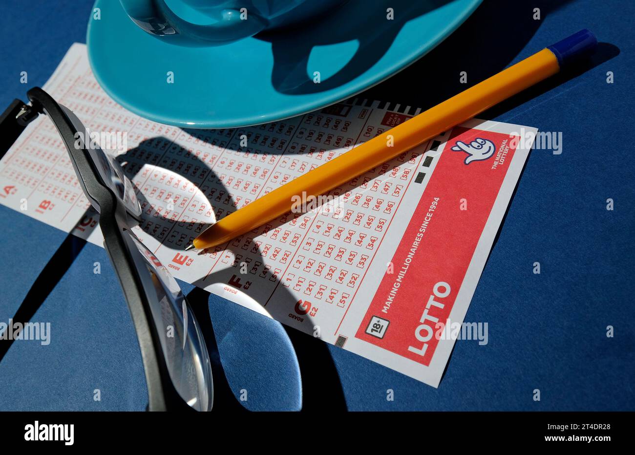 british lotto ticket and pen on blue background Stock Photo