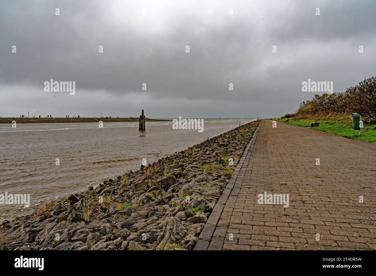 Drei Wege . Links ein Weg auf dem Deich, in der Mitte der Schiffweg aus dem Hafen, links ein Fußweg mit Sitzbänken Stock Photo