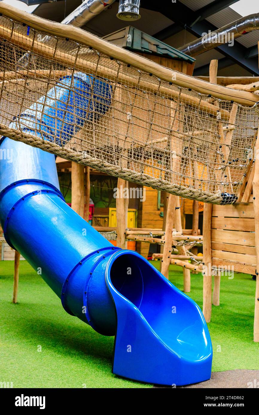 Closeup of blue tube slide and rope bridge with side netting at Monty