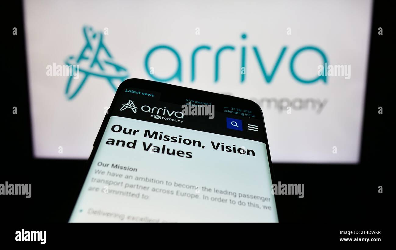 Smartphone with webpage of British public transport company Arriva plc in front of business logo. Focus on top-left of phone display. Stock Photo