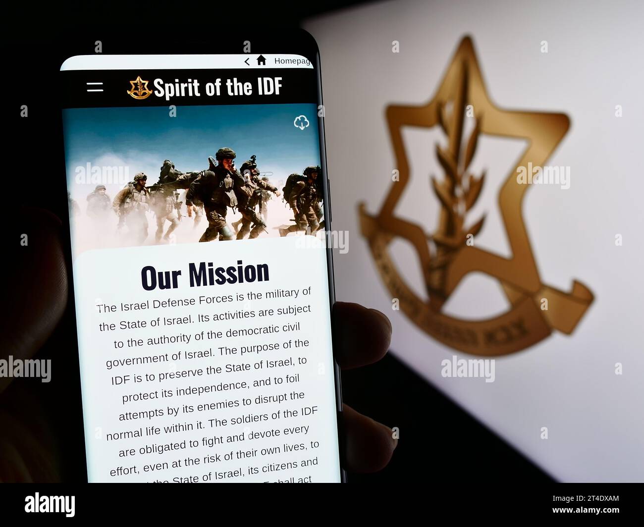 Person holding cellphone with webpage of national military Israel Defense Forces (IDF) in front of logo. Focus on center of phone display. Stock Photo