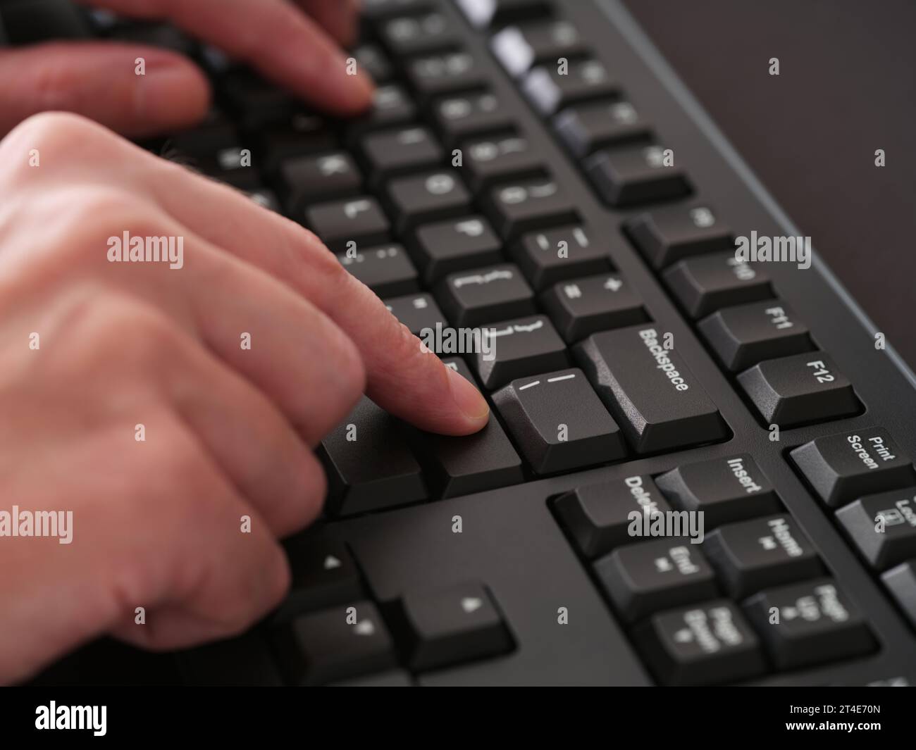 A man typing on a black computer keyboard. Close up. Stock Photo
