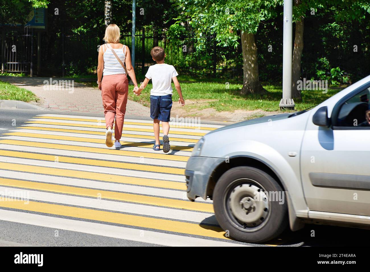 Mother and child walk on pedestrian crossing Stock Photo