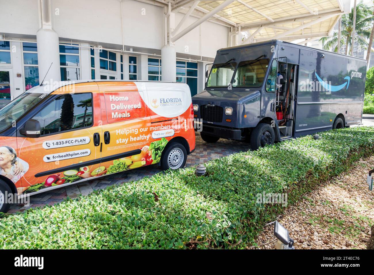 Miami Beach Florida,outside exterior,building front entrance hotel,Collins Avenue,Amazon Prime delivery EV electric van vehicle,home delivered meals l Stock Photo
