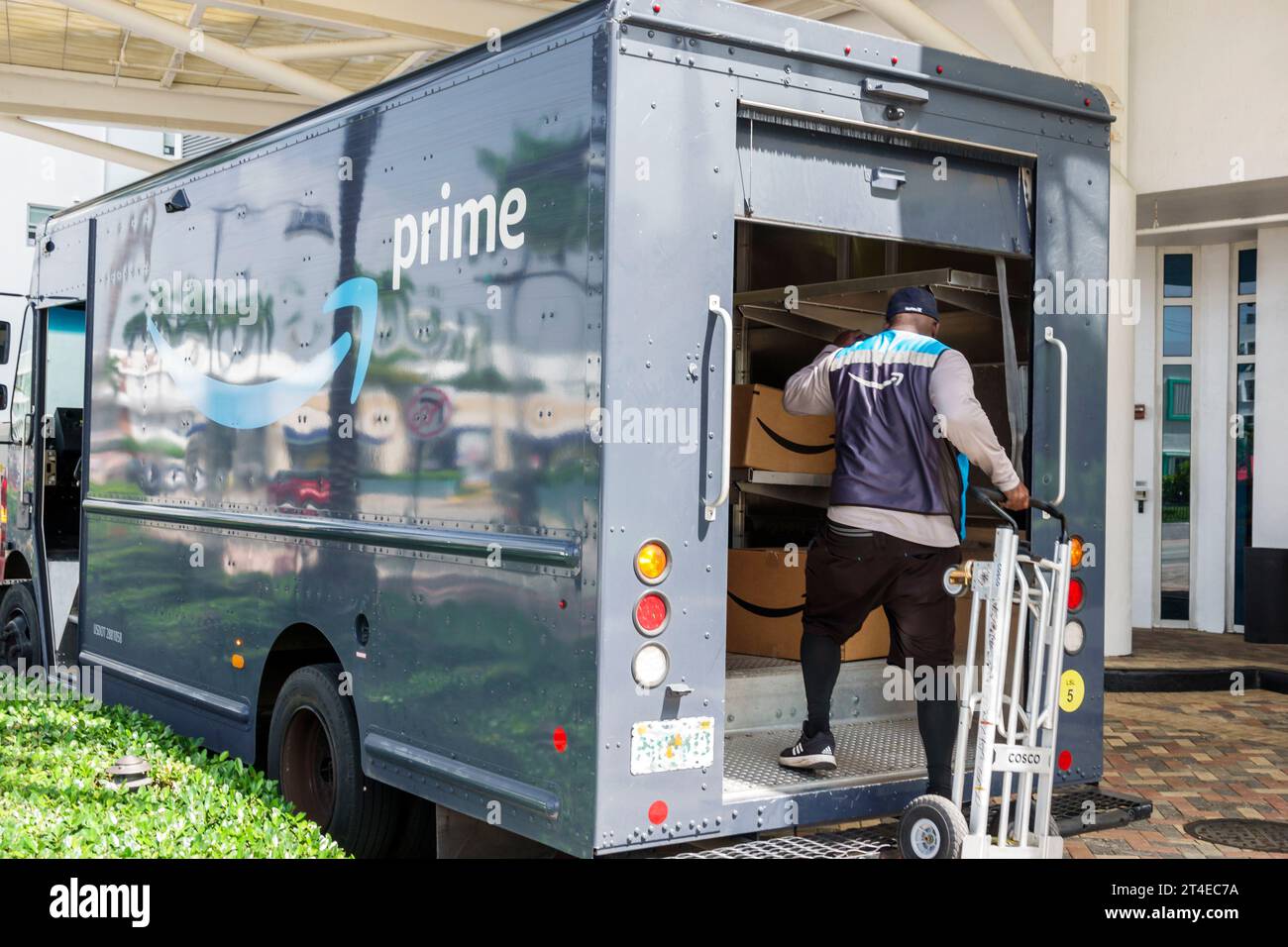 Miami Beach Florida,outside exterior,building front entrance hotel,Collins Avenue,Amazon Prime delivery EV electric van vehicle,driver man men male,ad Stock Photo