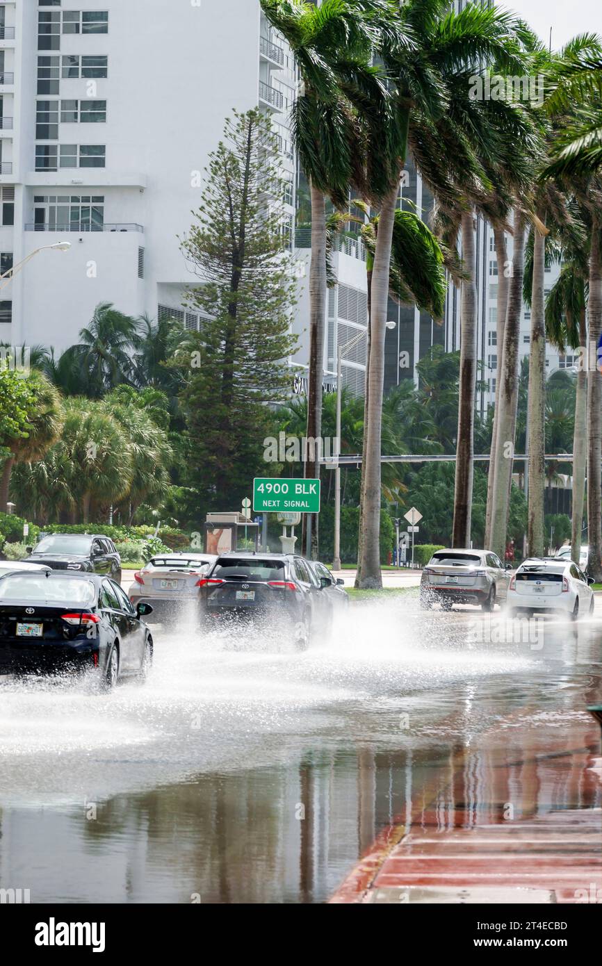 Miami Beach Florida,Collins Avenue,king high tide flooding,rising sea level climate change,vehicles traffic splashing through seawater Stock Photo