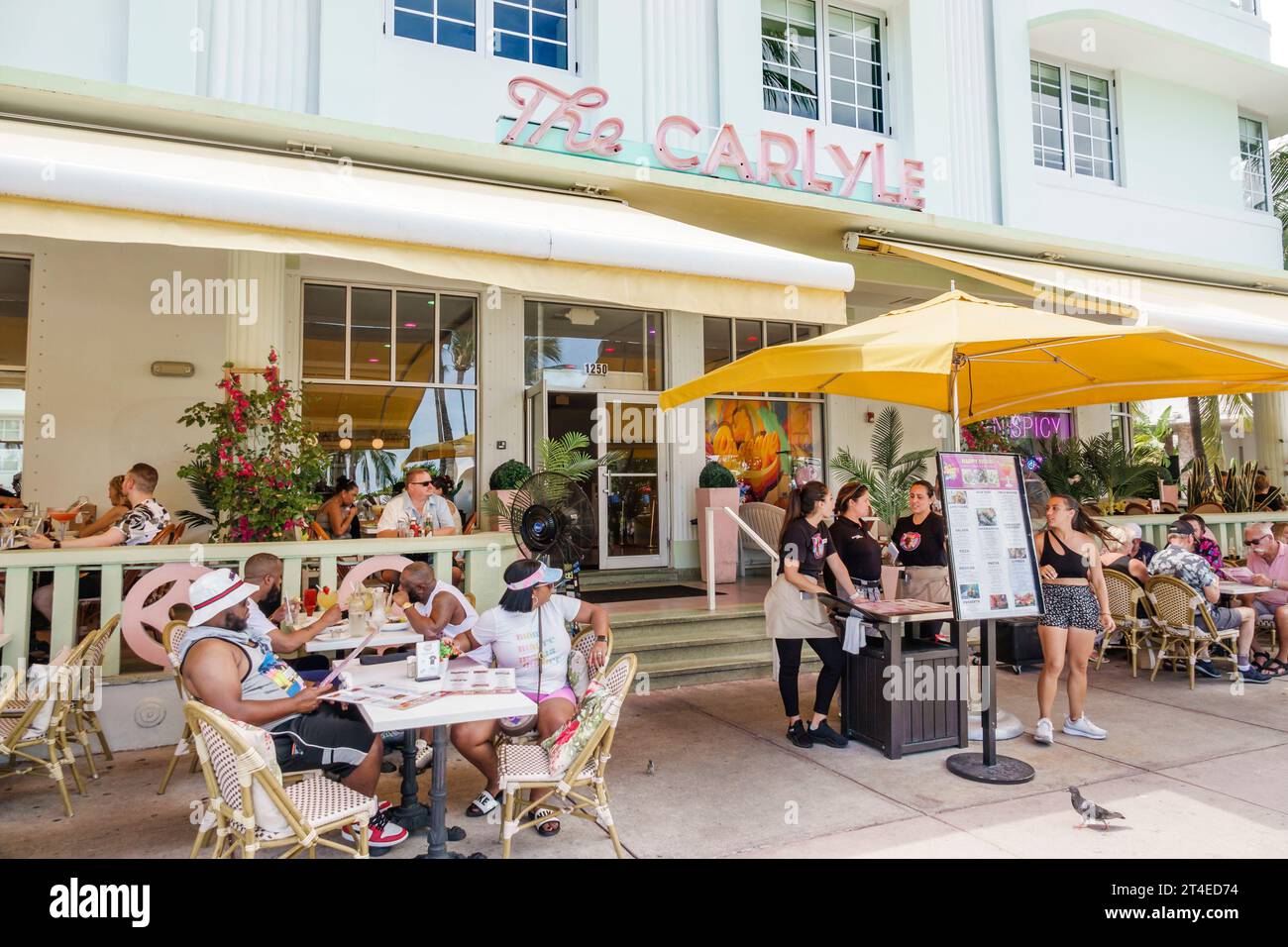 Miami Beach Florida,outside exterior,building front entrance hotel,Ocean Drive,Carlyle Cafe sign,man men male,woman women lady female,adults residents Stock Photo