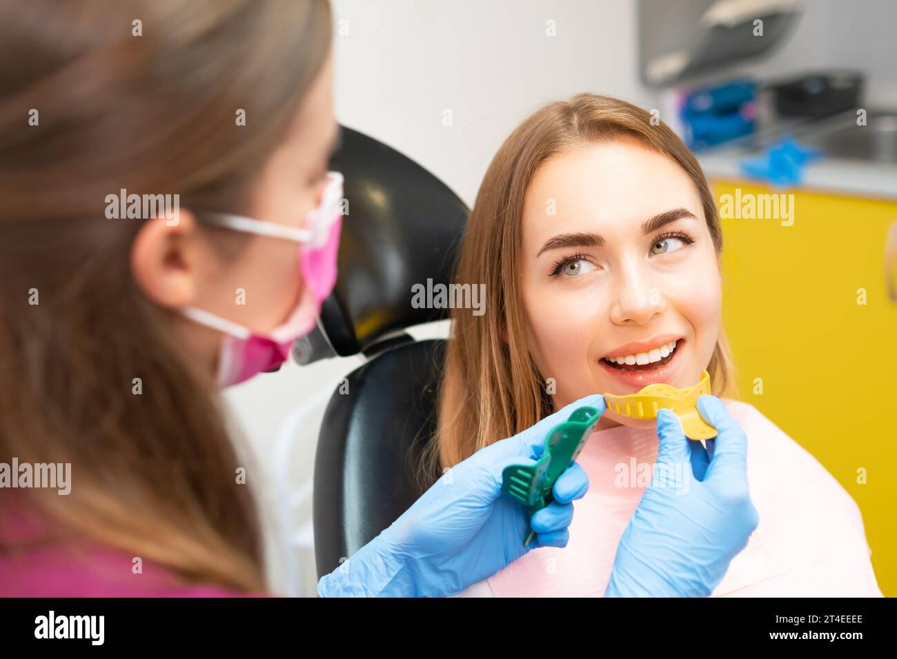 Dentist picks out plastic molds to create dental impressions to make