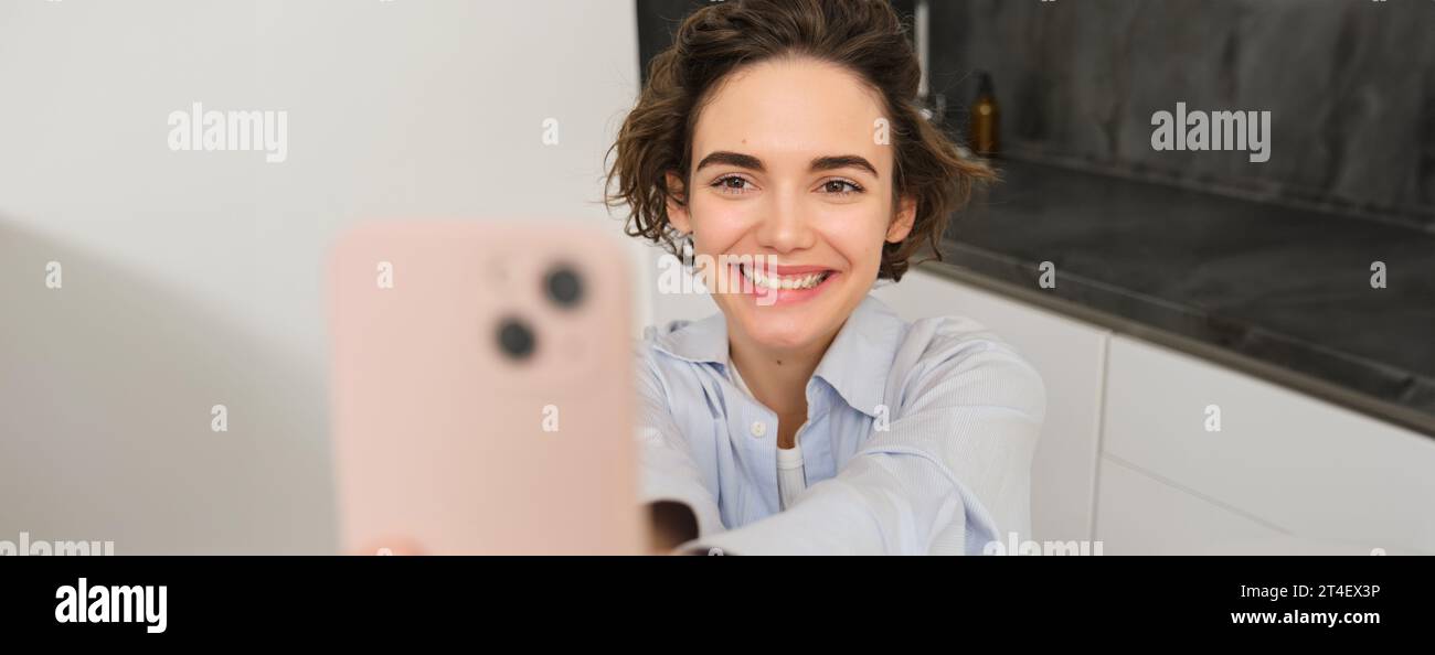 Portrait of beautiful young woman, taking selfie on mobile phone at ...