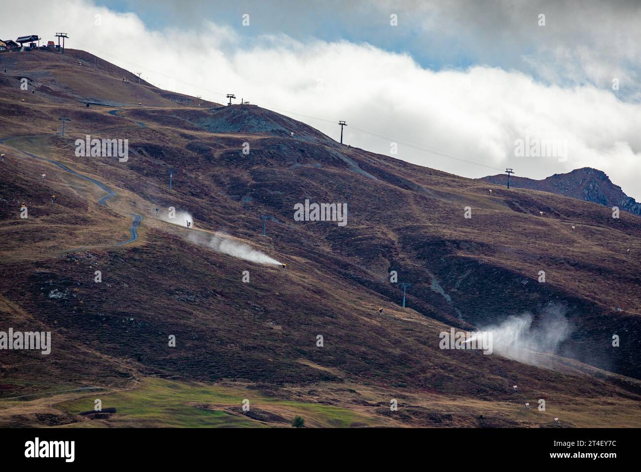 Snow cannons in fall. Snow-guns spraying artificial ice crystals. No natural snow on the mountains - Davos, Switzerland Stock Photo