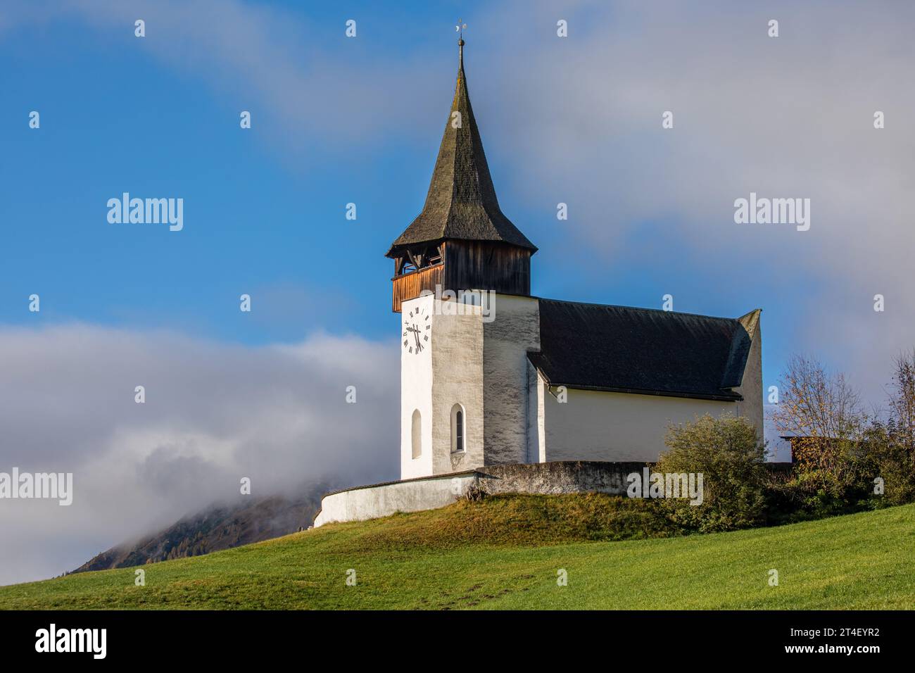 Reformierte Kirche church in the autumn Alps. Amazing landscape with small chapel on sunny meadow at Davos Frauenkirch, Davos, Switzerland Stock Photo