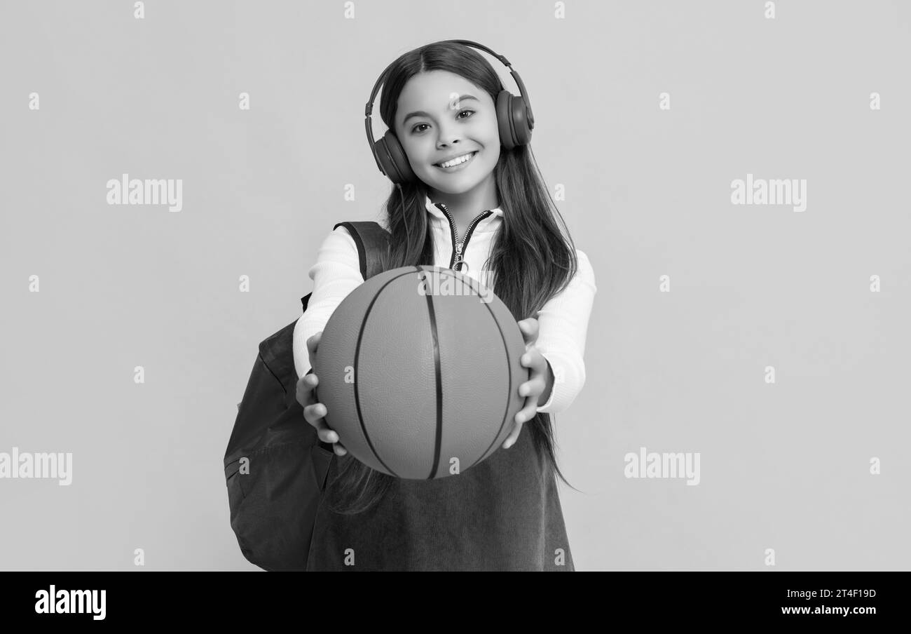 happy child in headphones with school backpack and basketball ball. selective focus Stock Photo