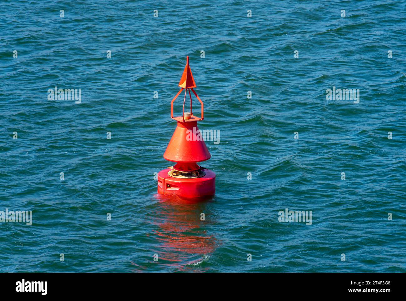 A red channel marker floating on ocean water Stock Photo