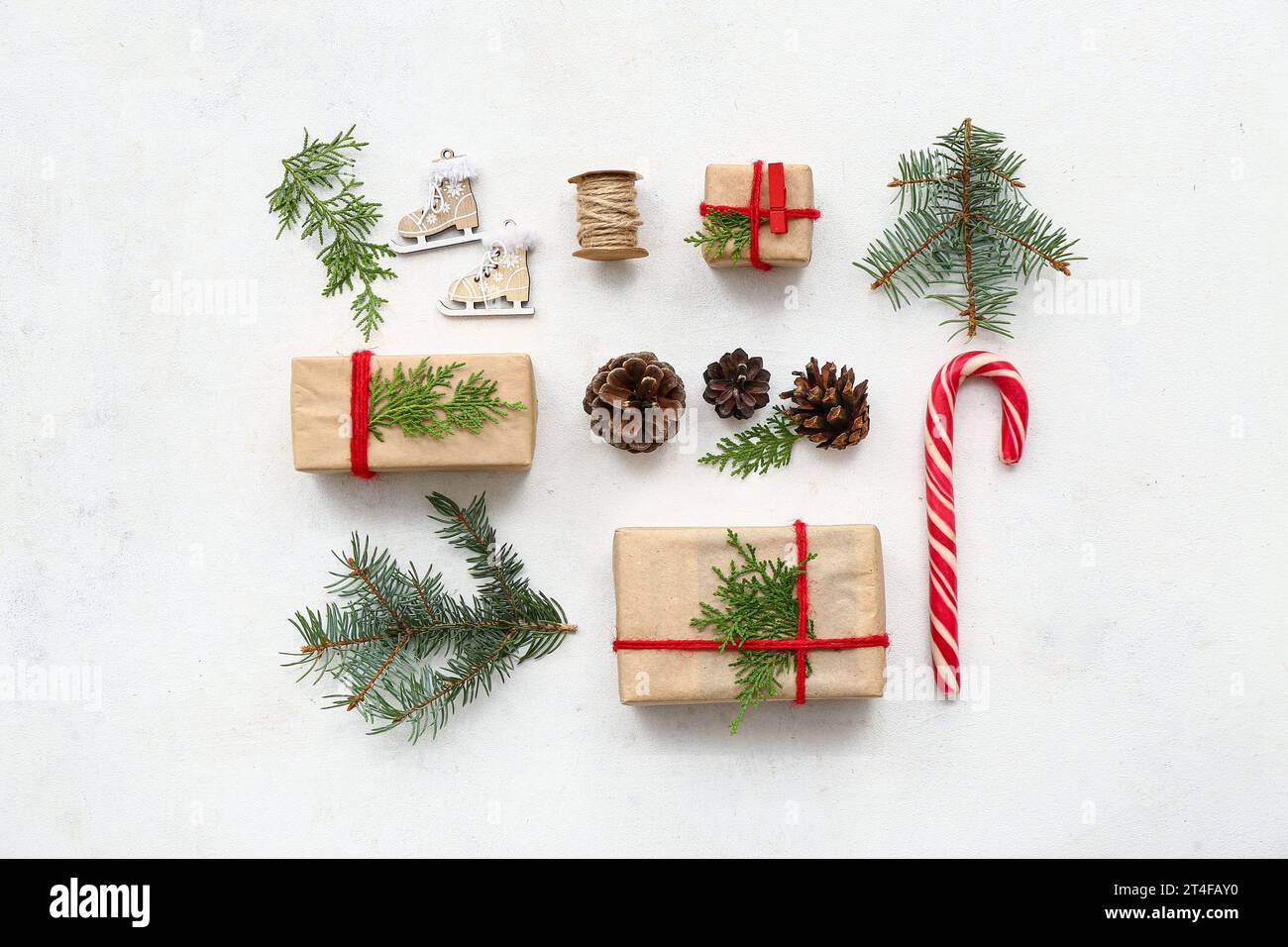 Gift boxes with Christmas tree branches, cones and candy cane on white ...