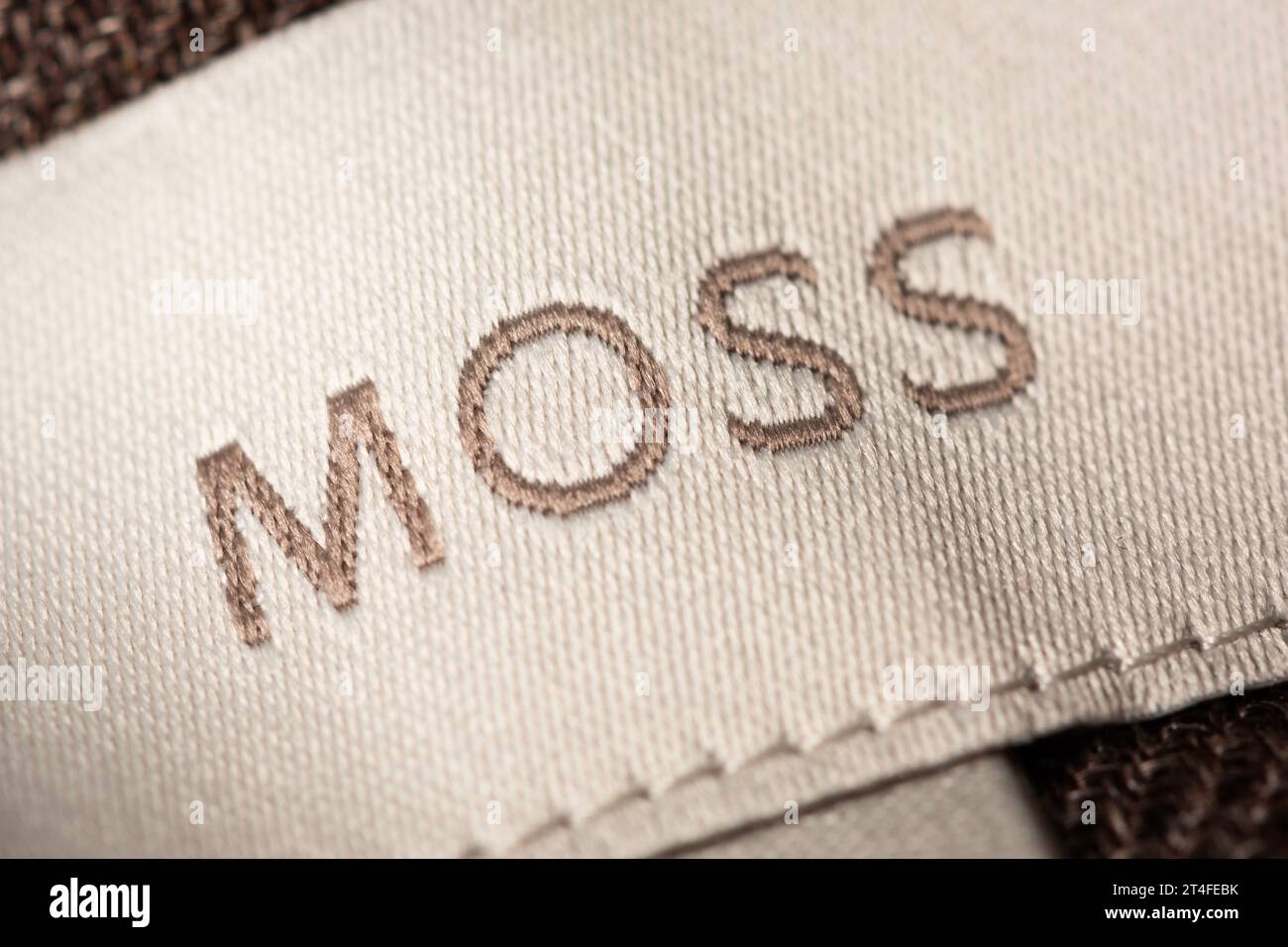A close-up of an embroidered Moss logo as seen on a tag. Stock Photo
