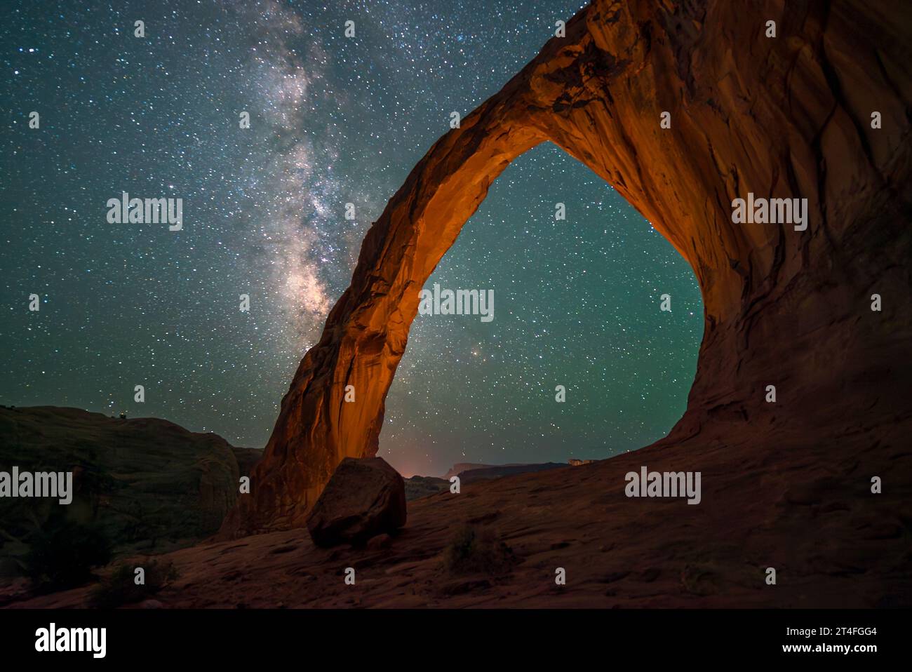 One cannot help but feel awe while taking in a star filled sky in the shadow of the Corona Arch, also known as Little Rainbow Bridge, near Moab, Utah. Stock Photo