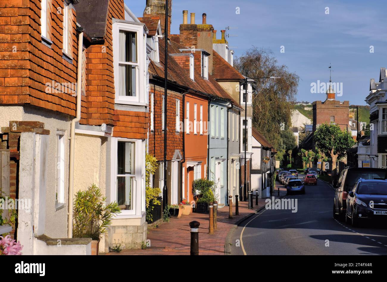 Lewes: Period houses along Southover High Street with Trinity Church and chalk cliff soon before sunset in Lewes, East Sussex, England, UK Stock Photo