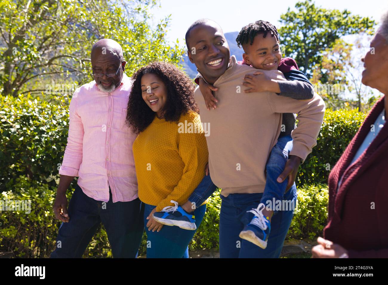 Happy african american family walking and talking in sunny backyard, copy space Stock Photo
