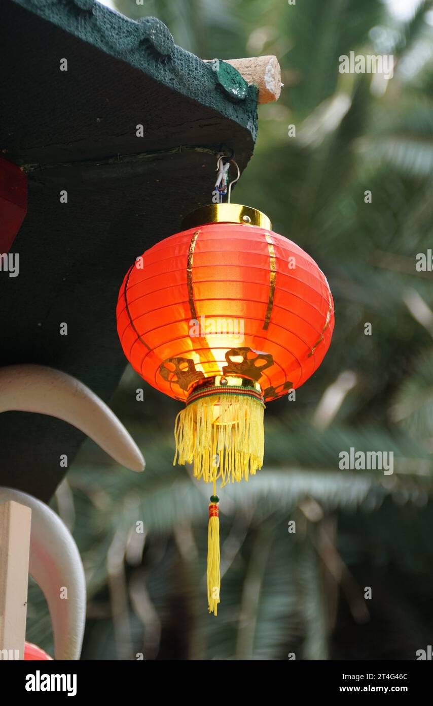 A Chinese red lantern hanging on the side of a roof Stock Photo - Alamy