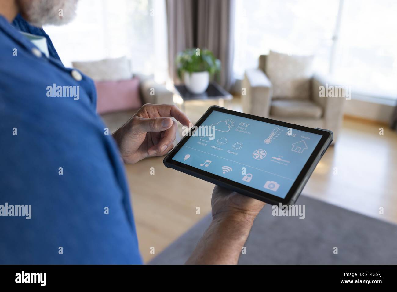 Midsection of senior caucasian man using tablet with smart home interface Stock Photo