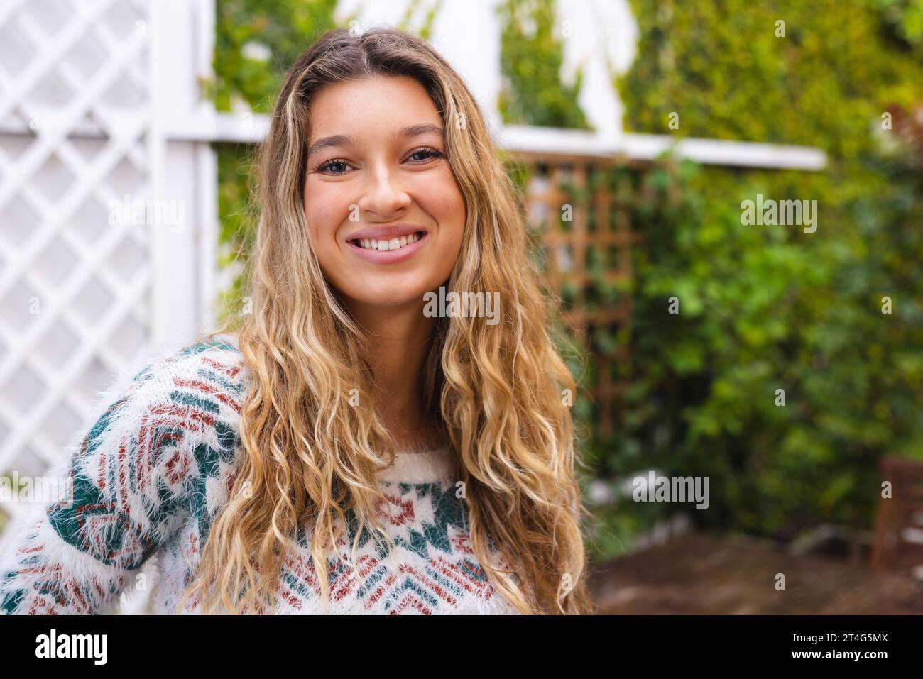Portrait of happy caucasian woman with long blonde hair smiling in garden, copy space Stock Photo