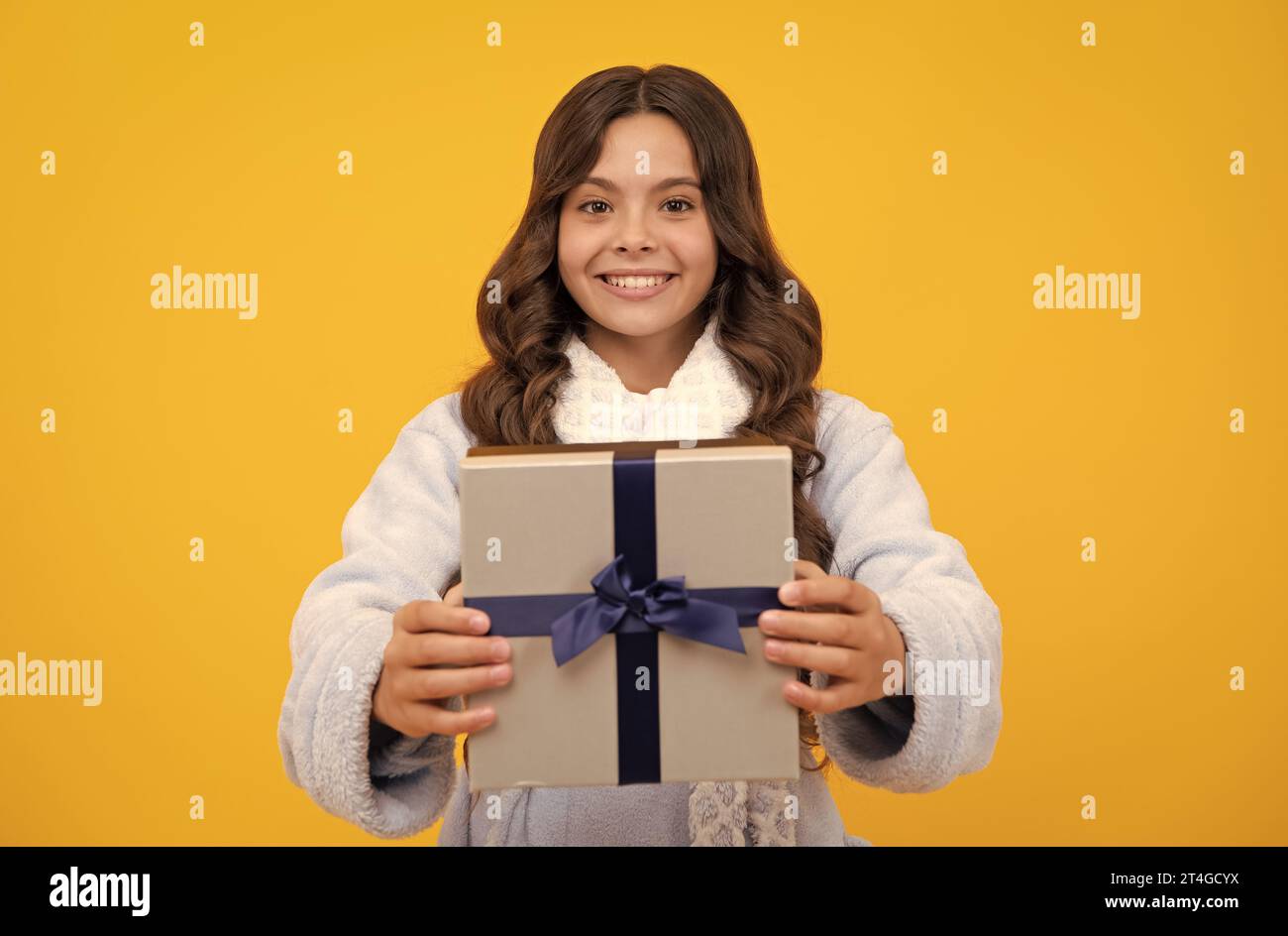 Portrait of a teenager child girl holding present box isolated over ...