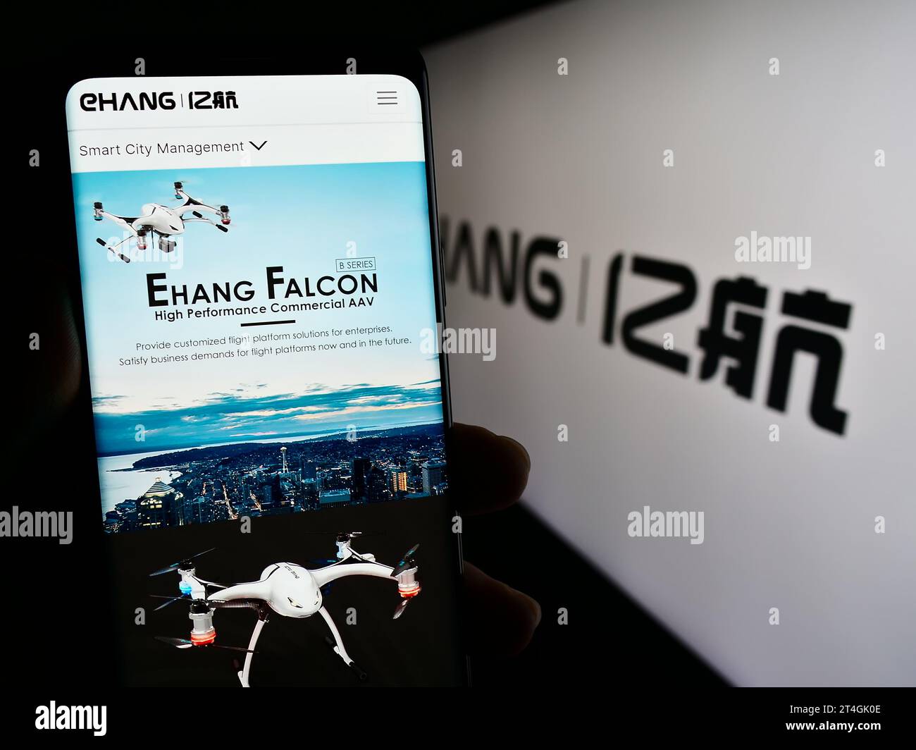 Person holding mobile phone with web page of Chinese aviation company EHang Holdings Limited in front of logo. Focus on center of phone display. Stock Photo
