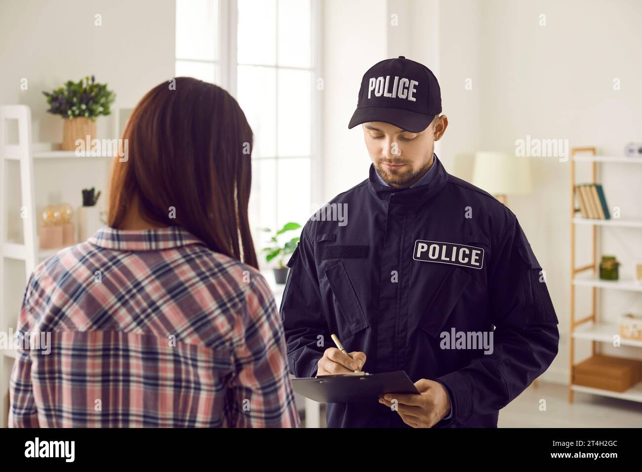 Police officer taking notes while interrogating witness, victim or