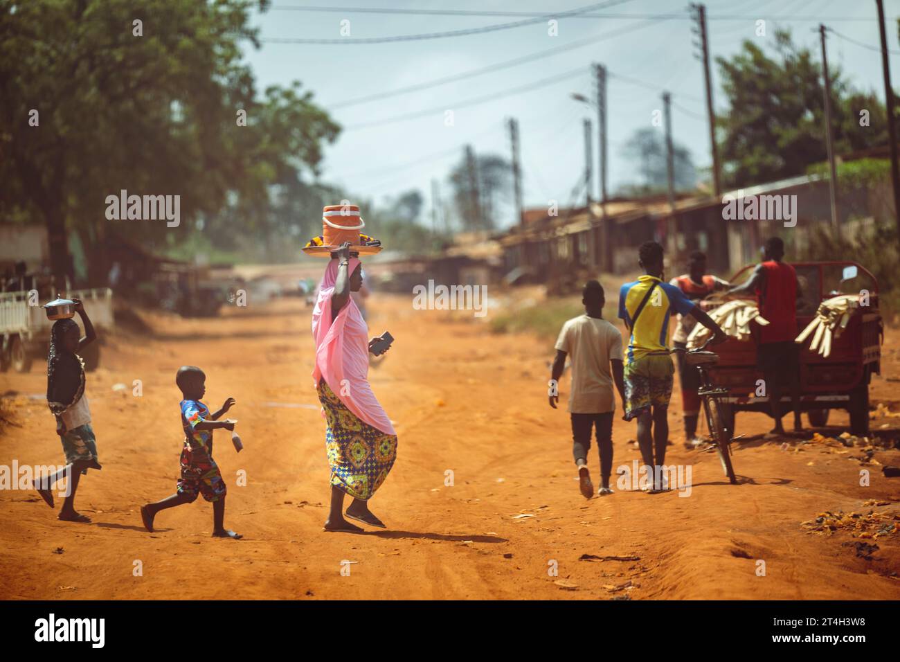 A group of people walking together down a dusty country road carrying