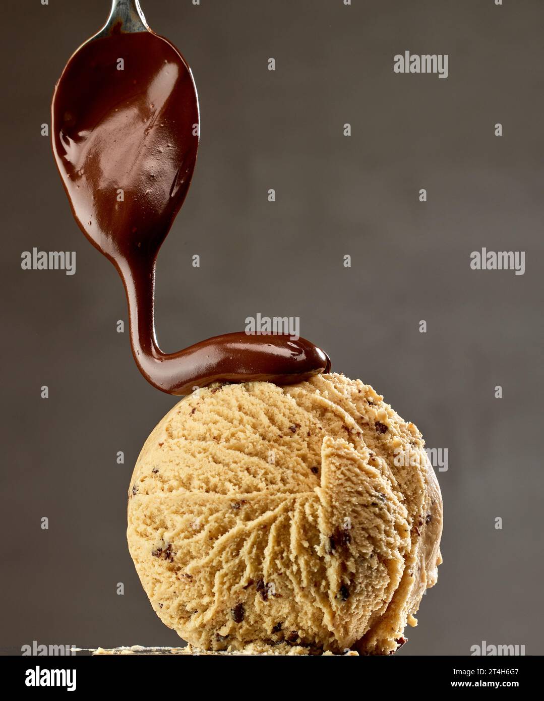 caramel ice cream with melted chocolate on dark grey background Stock Photo