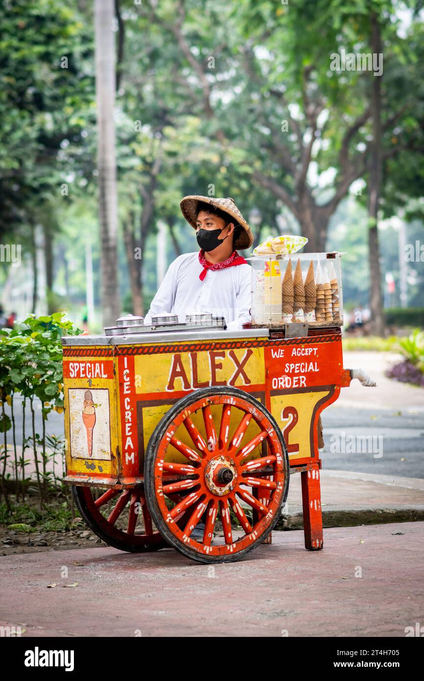 An ice cream vendor works from his classic beautiful designed cart in