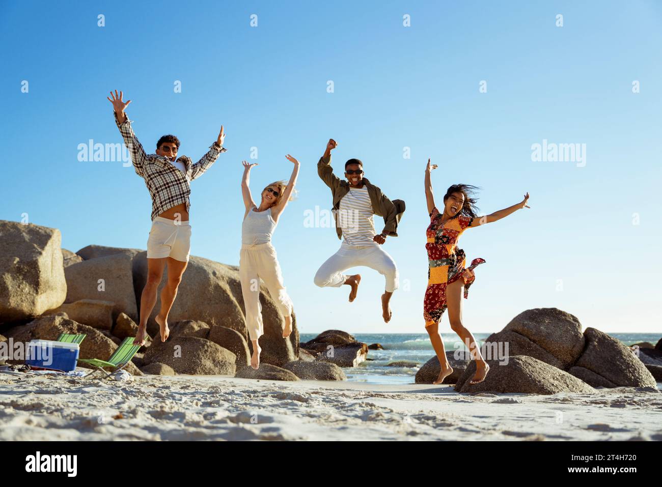 Four friends jumping on beach hi-res stock photography and images - Alamy