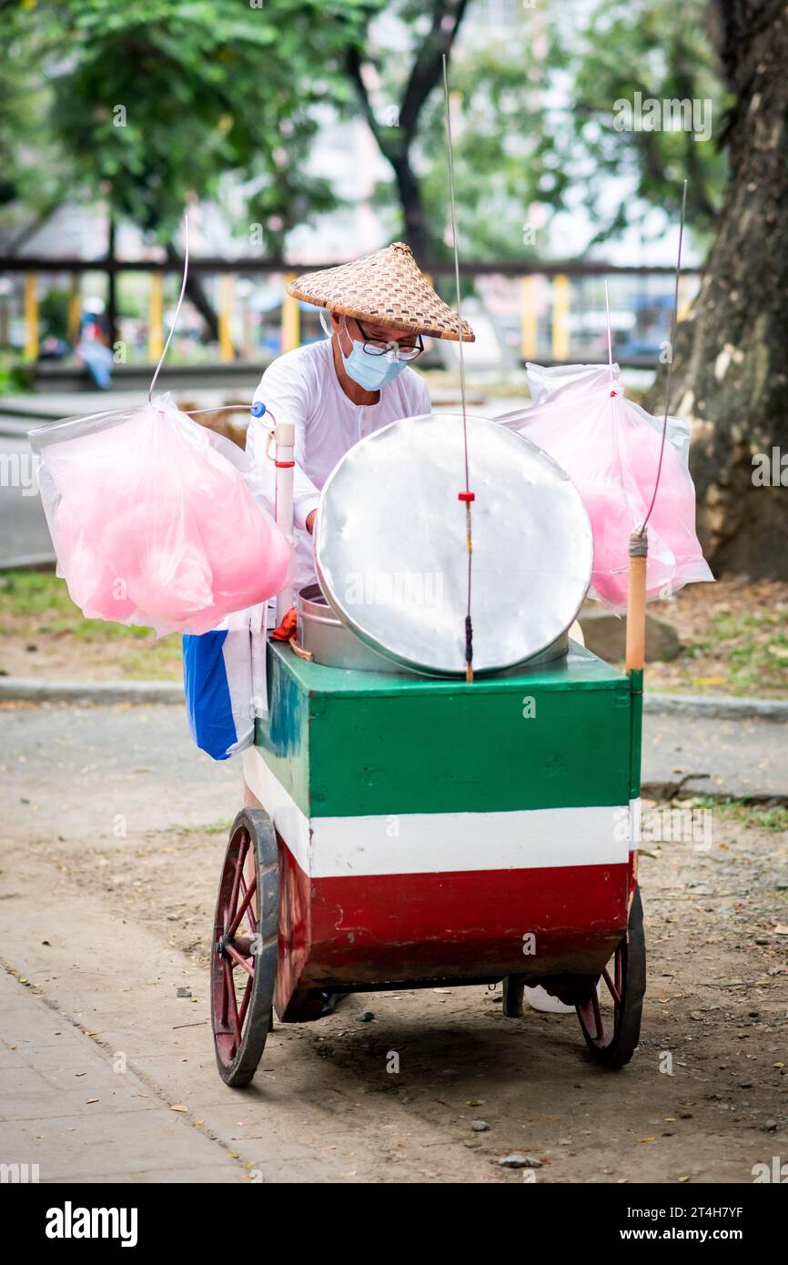 A candy floss vendor works from his cart in Rizal Park, Ermita, Manila