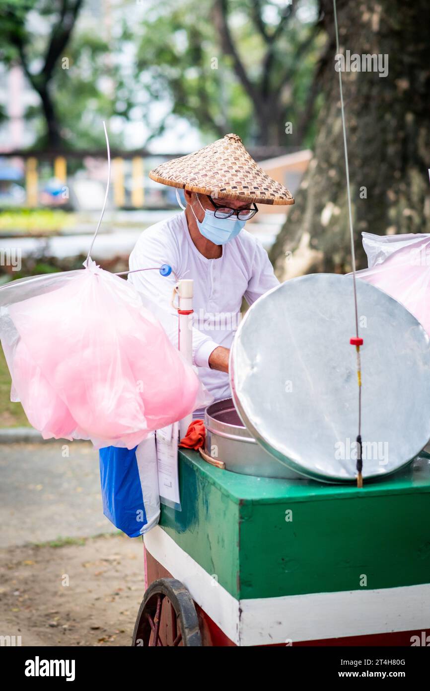 A candy floss vendor works from his cart in Rizal Park, Ermita, Manila