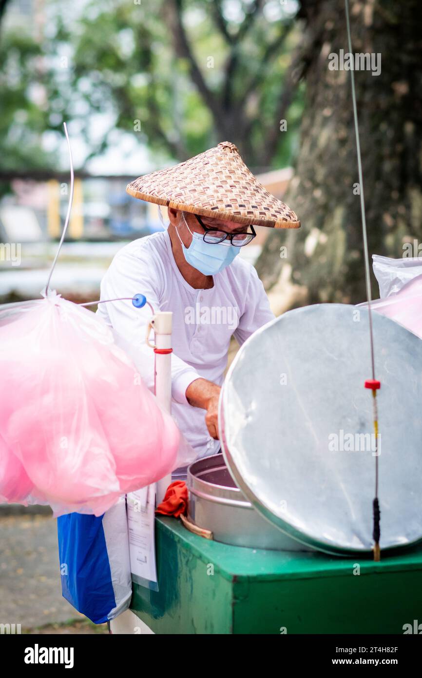 A candy floss vendor works from his cart in Rizal Park, Ermita, Manila