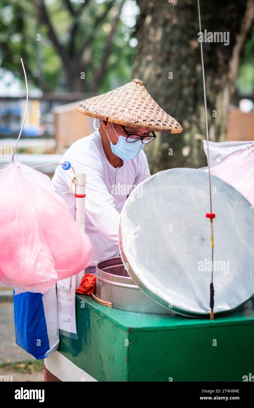 A candy floss vendor works from his cart in Rizal Park, Ermita, Manila