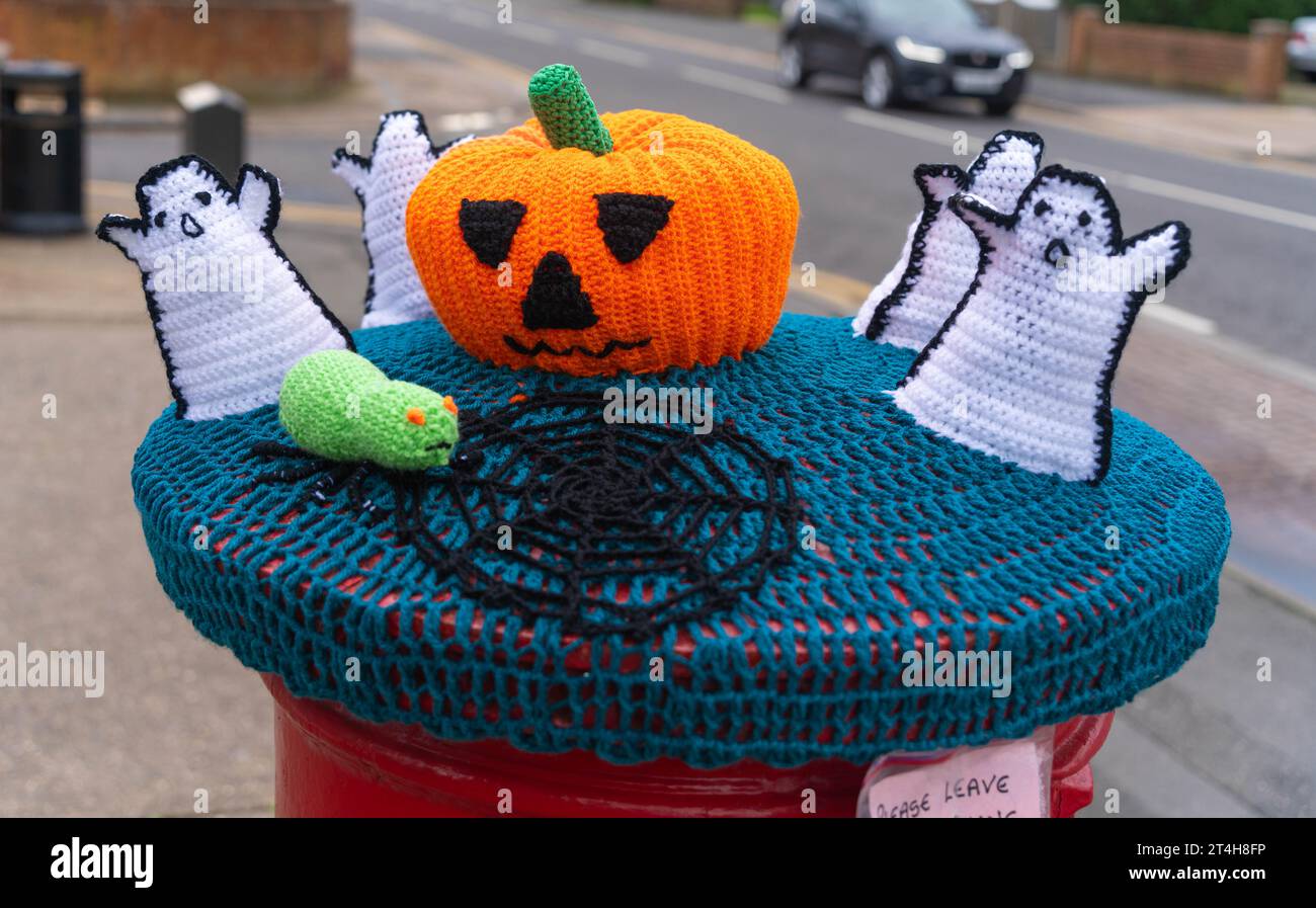 Red, postbox, post box, crocheted, Royal Mail, woolly hats, hand-knitted, pillar boxes, Lincoln City, Halloween, pumpkin, orange, ghost's, cobwebs. Stock Photo