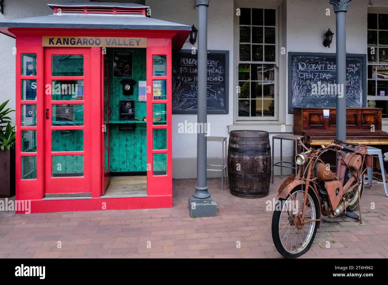 A vintage motorcycle and an old telephone box outside the Friendly Inn, Kangaroo Valley, New