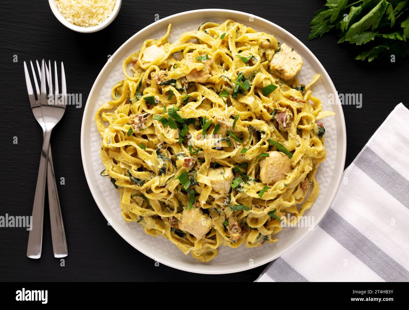 Homemade Creamy Chicken Bacon Pesto Pasta on a Plate on a black