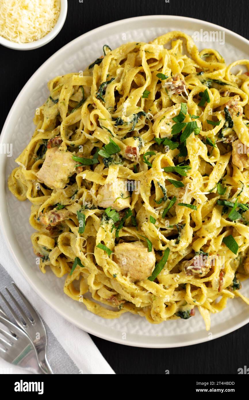 Homemade Creamy Chicken Bacon Pesto Pasta on a Plate on a black