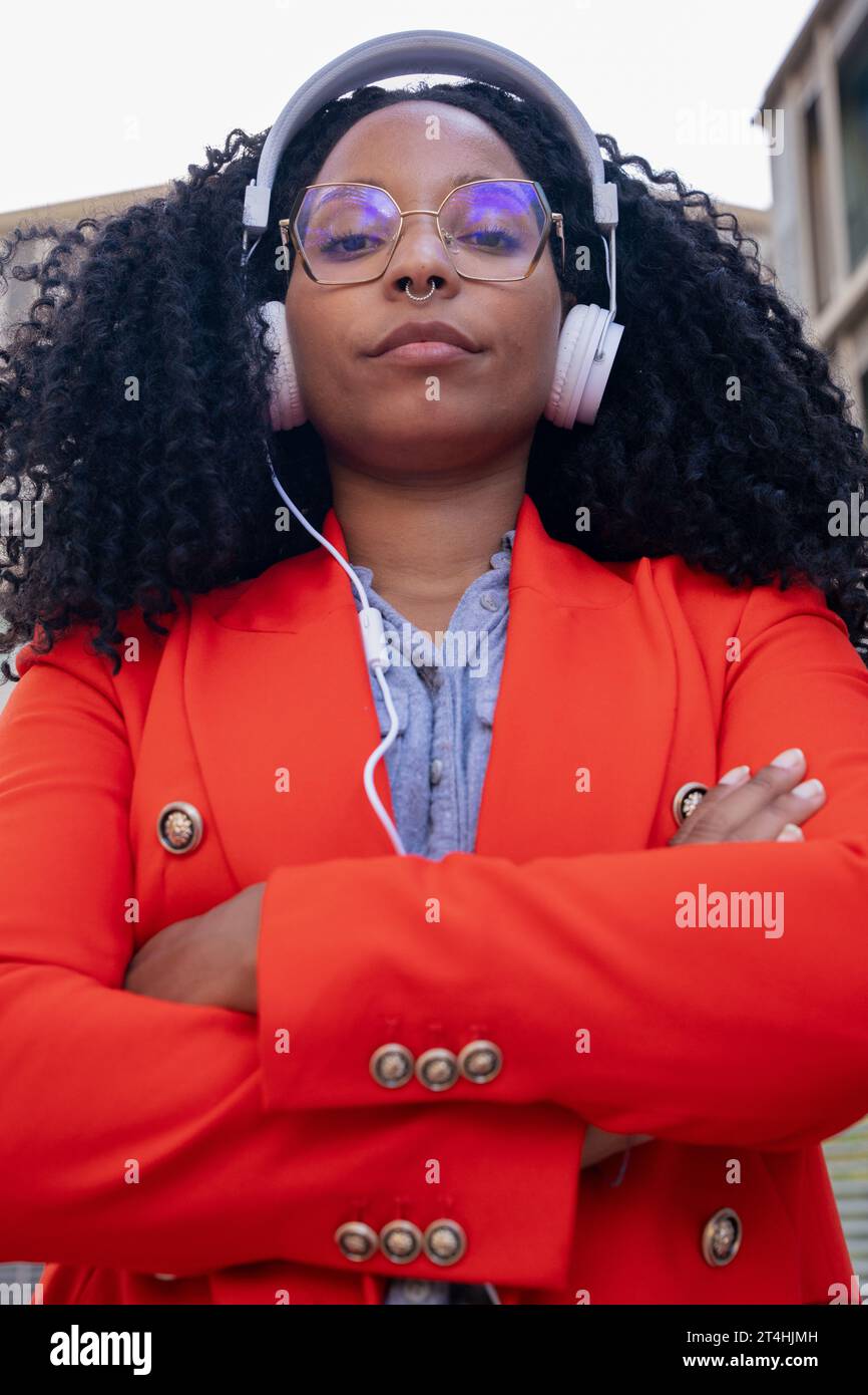 Single close up of serious African American businesswoman standing looking at camera with arms crossed. Stock Photo