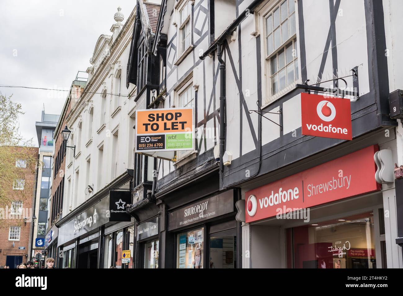 Shrewsbury, Shropshire, England, May 1st 2023. Vodafone mobile phone store with shop for sale sign in background, retail editorial illustration. Stock Photo