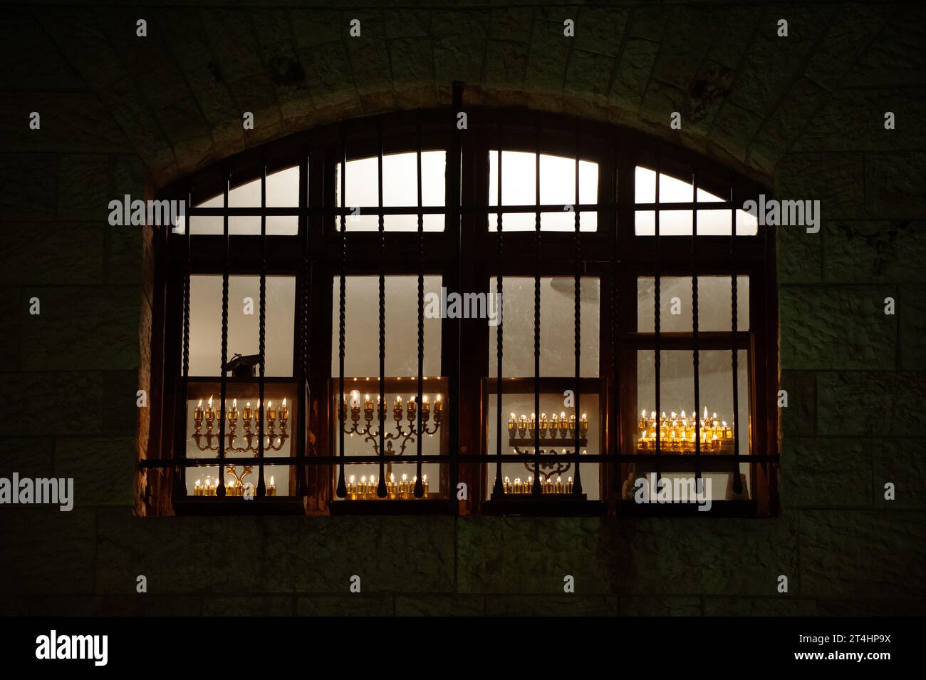 Glowing Hanukkah menorahs burn brightly with eight candles in an arched